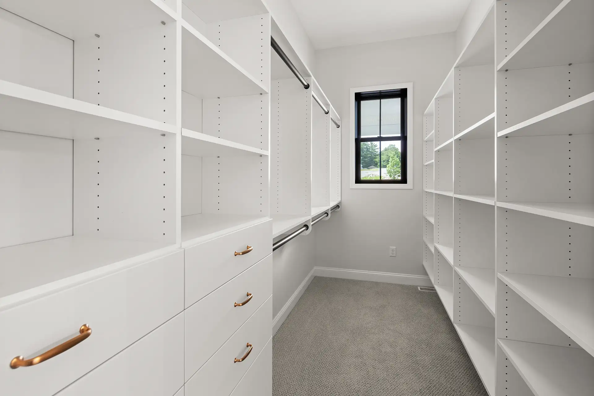 walk in closet white built ins gold hardware hanging rods window