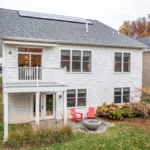 two homes with covered porches and autumn mountain backdrop