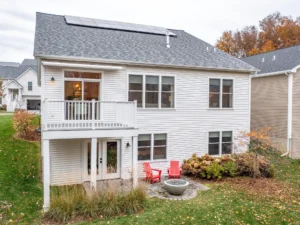 two homes with covered porches and autumn mountain backdrop