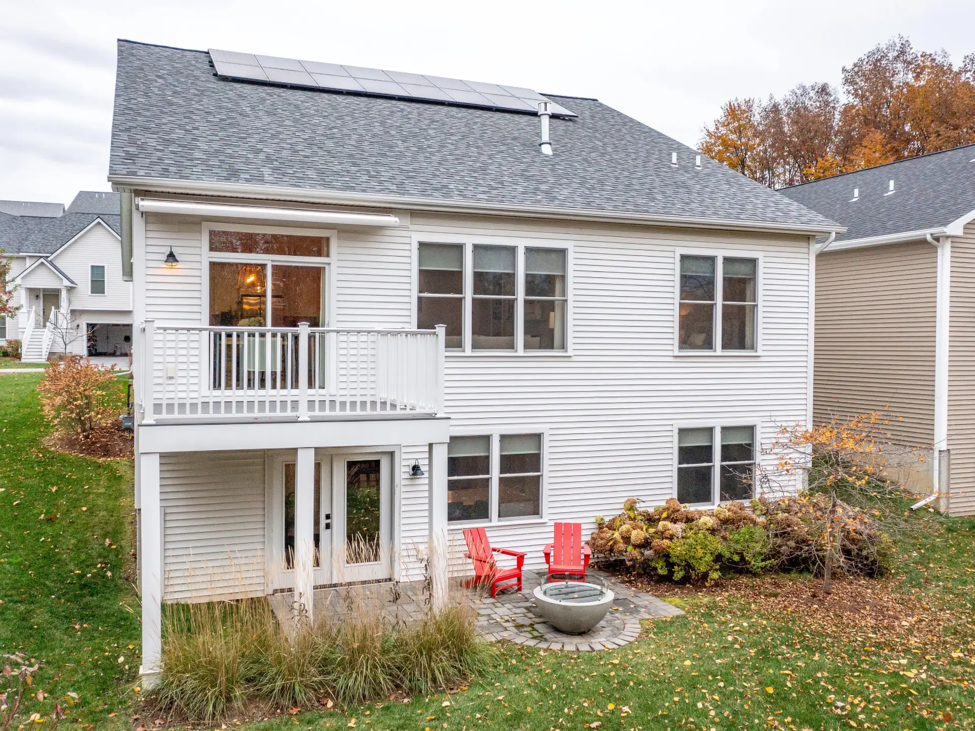 two homes with covered porches and autumn mountain backdrop