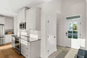 white kitchen stainless range tall cabinets glass entry door