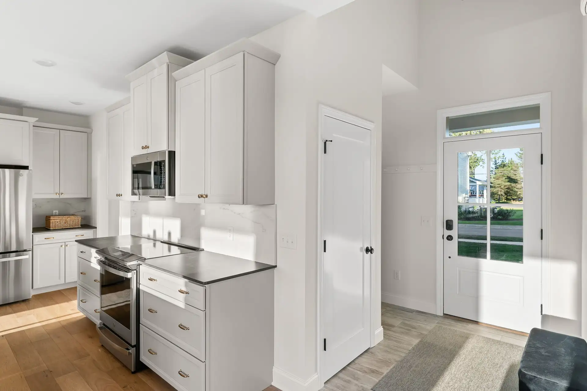 white kitchen stainless range tall cabinets glass entry door