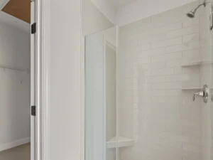 white subway tile shower with walk in closet view.